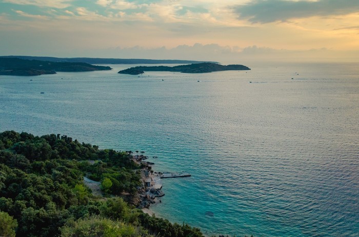 Islands in the sea at sunset with a green coastline