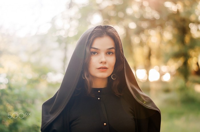 Woman in black clothing with hood outdoors