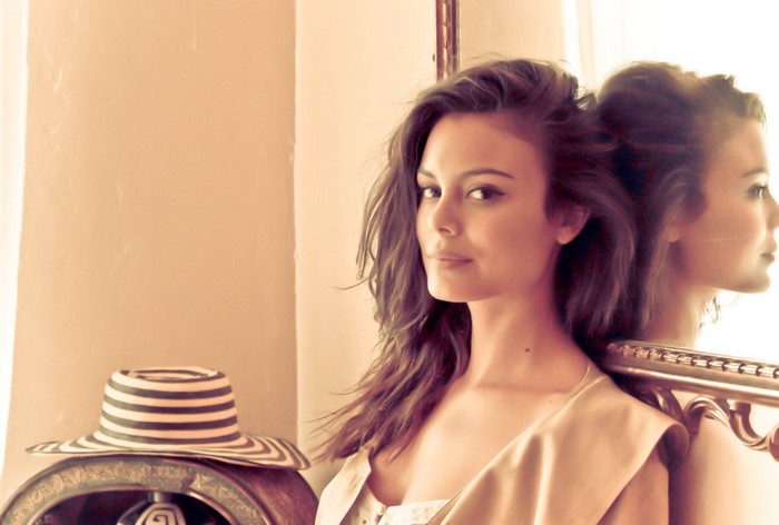 Nathalie Kelley leaning against a mirror