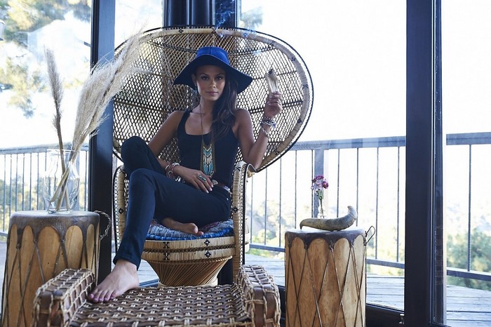 Nathalie Kelley sitting in a peacock chair