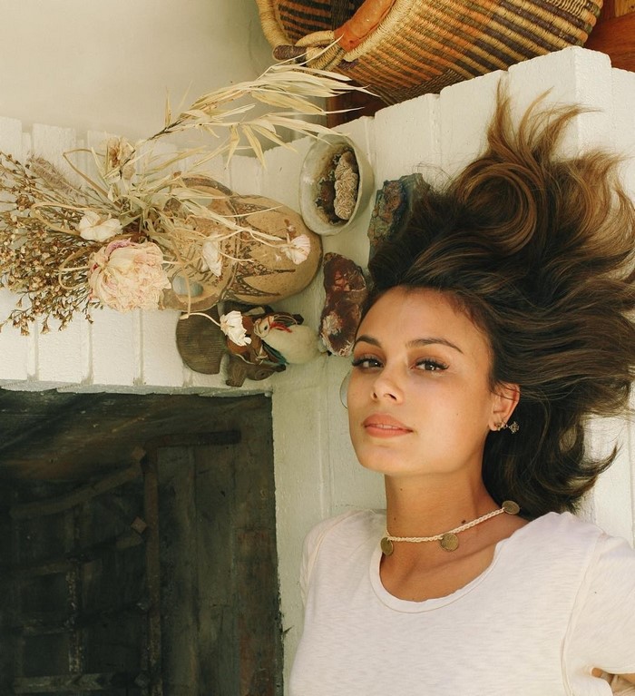 Nathalie Kelley lying down with dried flowers