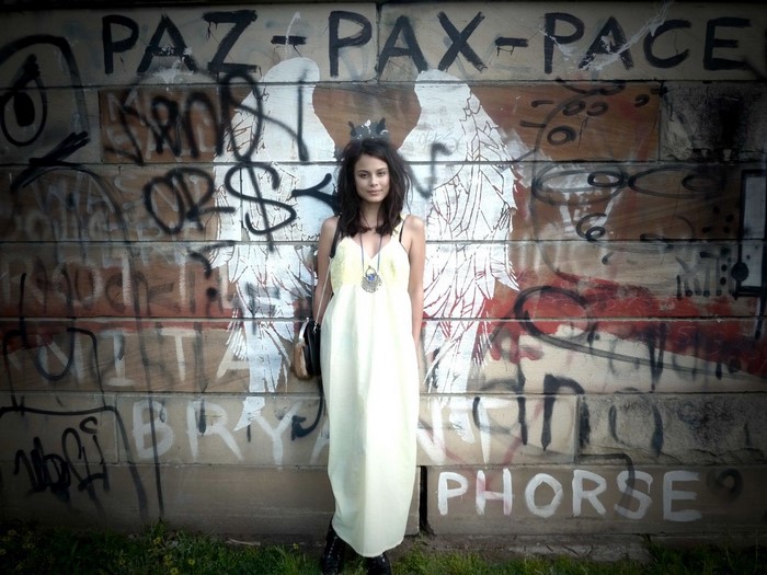 Nathalie Kelley in a yellow dress in front of graffiti art