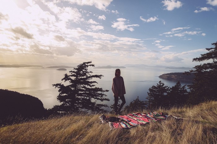 Woman on a hill overlooking islands at sunset