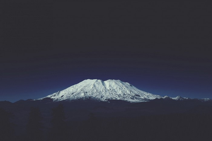 Snow-capped mountain range under a dark sky