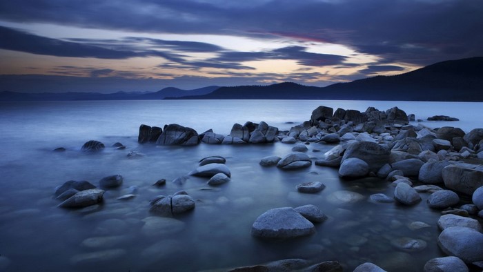 Rocky shore of a lake at dusk