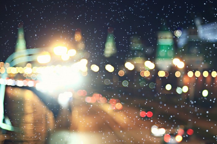 Blurred city lights at night with falling snow