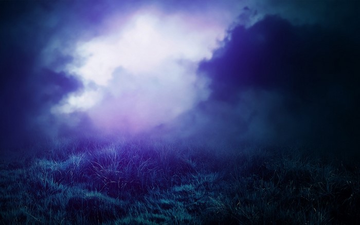 Dark clouds over a grassy field