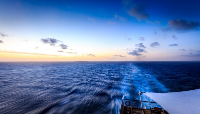 Boat wake on the ocean at sunset