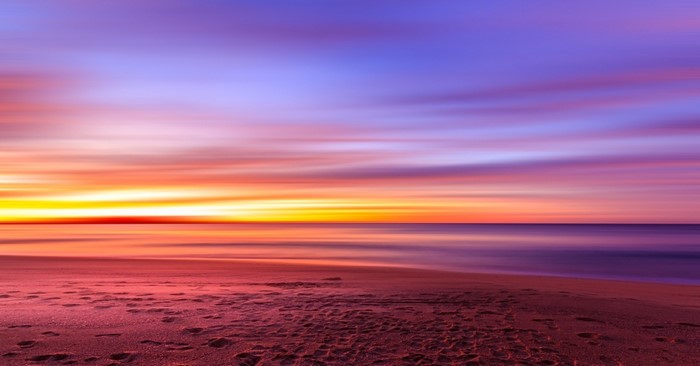 Sunset over the ocean with colorful sky and beach