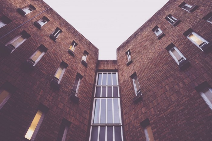 Brick building with many windows viewed from below