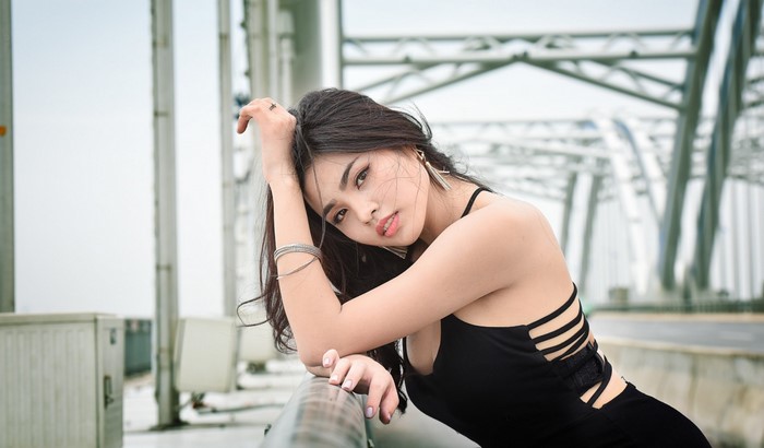 Asian woman posing on a bridge