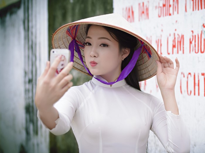 Woman in conical hat taking a selfie
