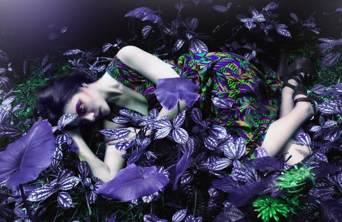 Woman in colorful dress lying in purple plants
