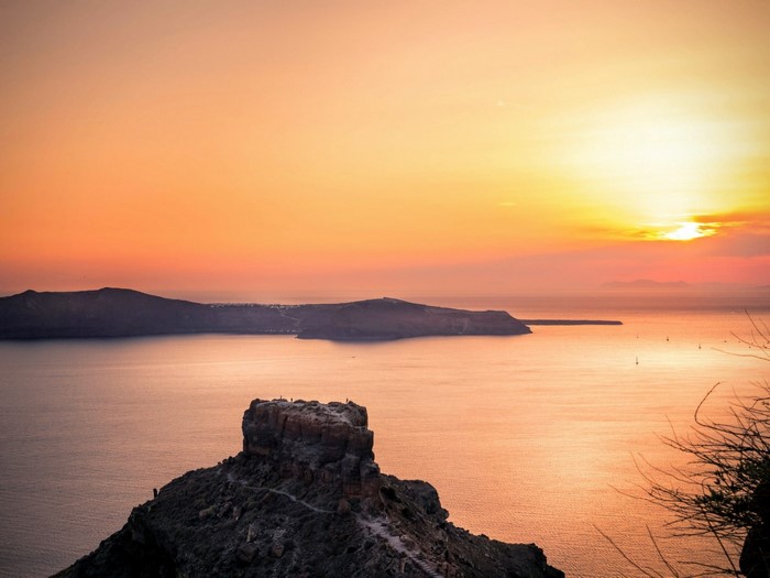 Sunset over the sea with islands and a rocky outcrop