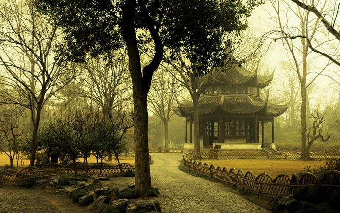 Asian temple in a misty park with a stone path