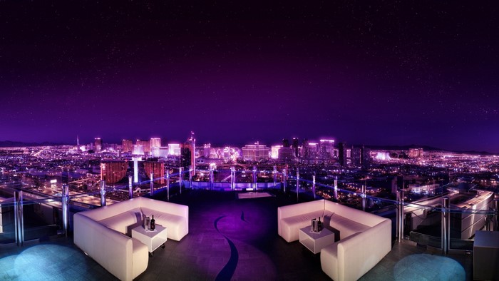 Rooftop lounge overlooking a city at night