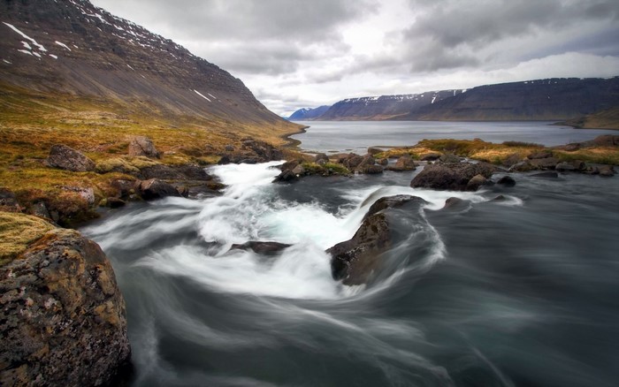 River flowing through a fjord with mountains