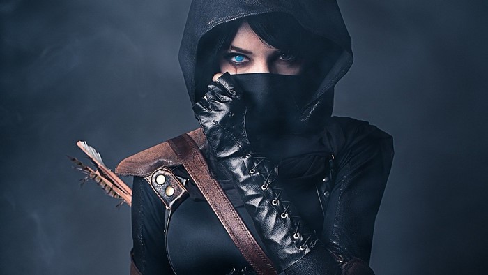 Woman in Thief cosplay with blue eyes and hood