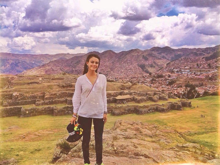 Nathalie Kelley in front of ancient ruins and a city