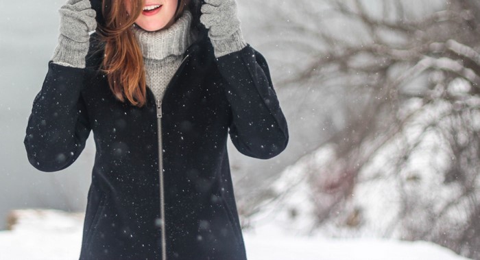 Woman in winter coat and gloves in snow