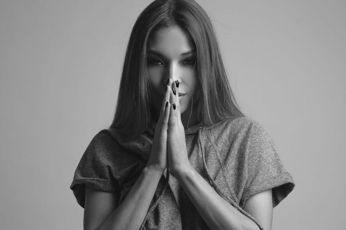 Monochrome portrait of a woman with hands clasped