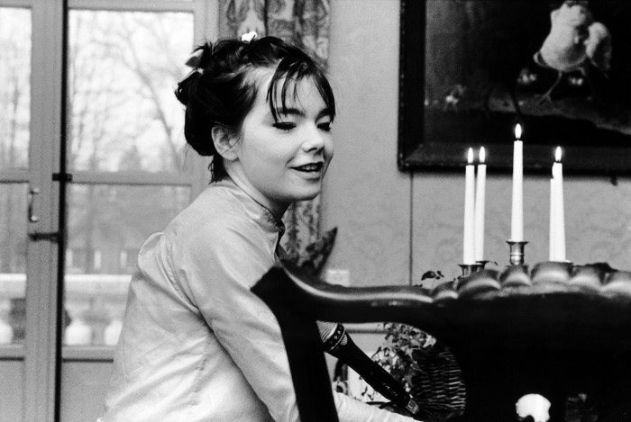Björk in a satin dress with candles and a microphone