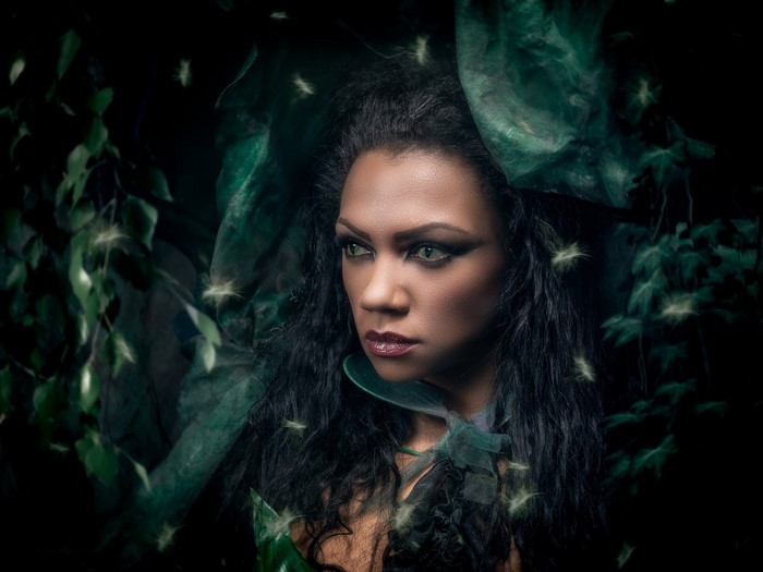 Woman with green eyes in a dark forest