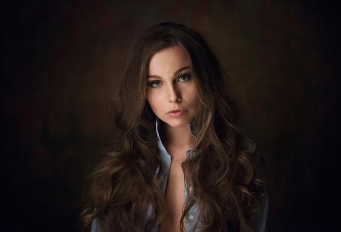 Woman with long brown hair wearing a blue shirt