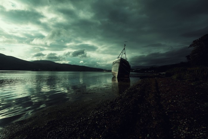 Shipwreck on a lake under stormy skies