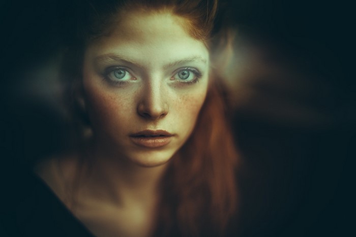 Close-up portrait of a redhead woman with blue eyes