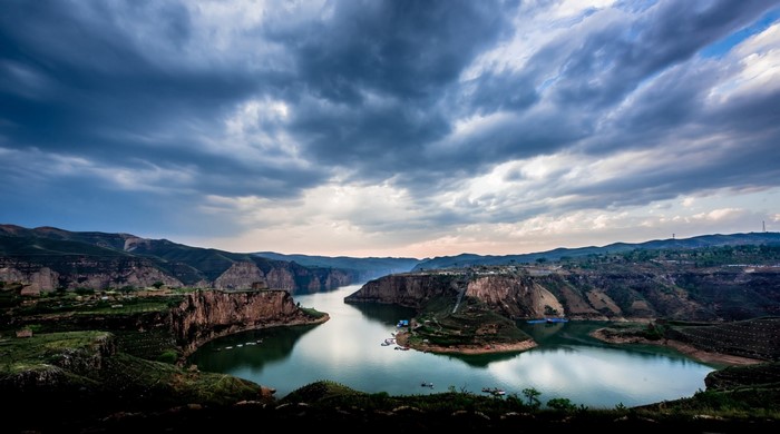 River flowing through a canyon with dramatic clouds