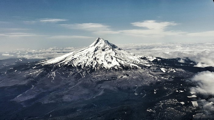 Mount Hood volcano covered in snow with clouds below