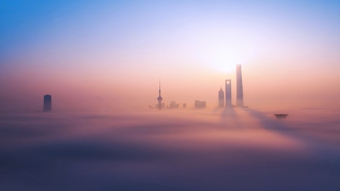 Shanghai skyline shrouded in fog at sunrise