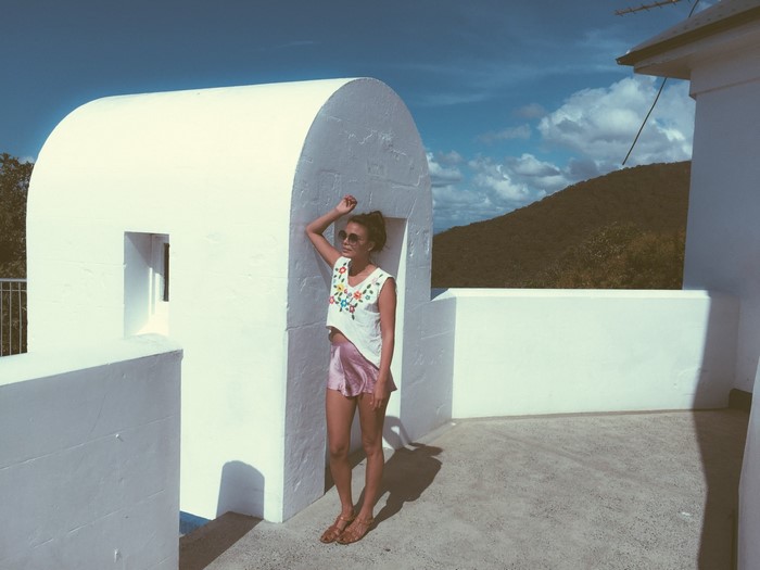 Nathalie Kelley on a white balcony with mountains in the background