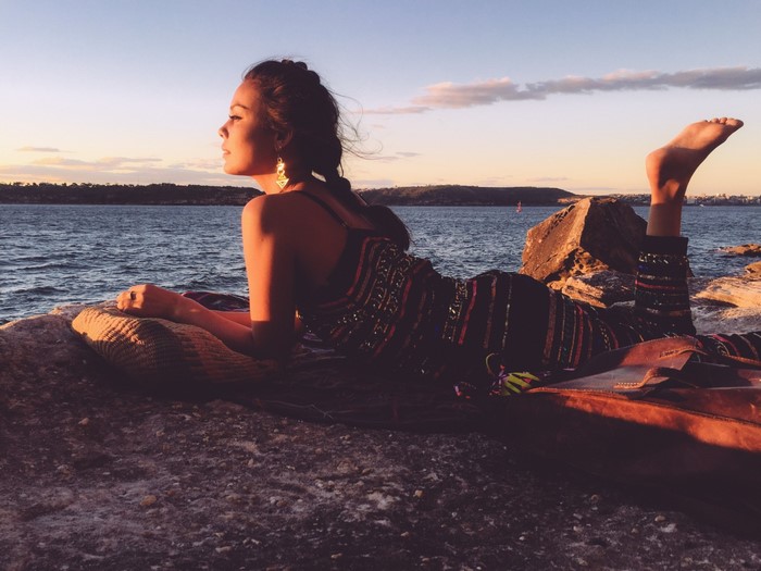 Nathalie Kelley on a rocky shore at sunset