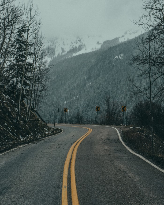 Winding mountain road in winter with snow-covered trees