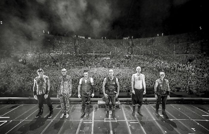 Rammstein band members on stage with a large crowd