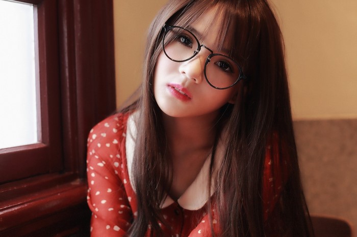 Young woman with glasses wearing a red dress