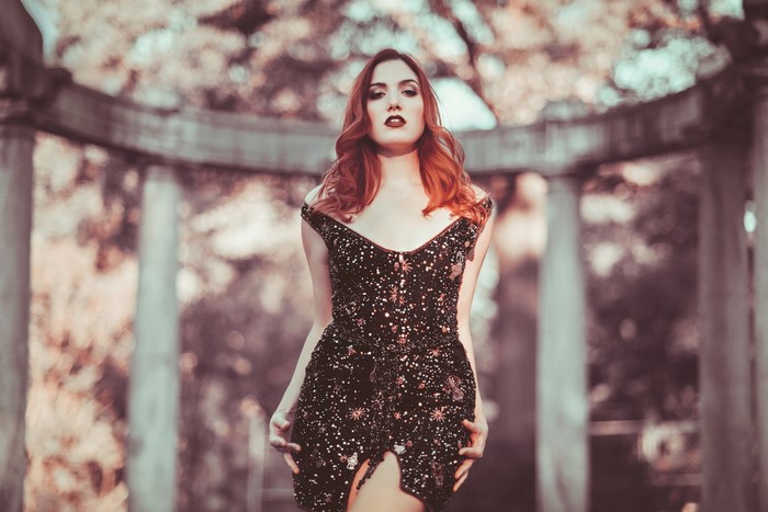 Woman with red hair in a sparkly black dress outdoors