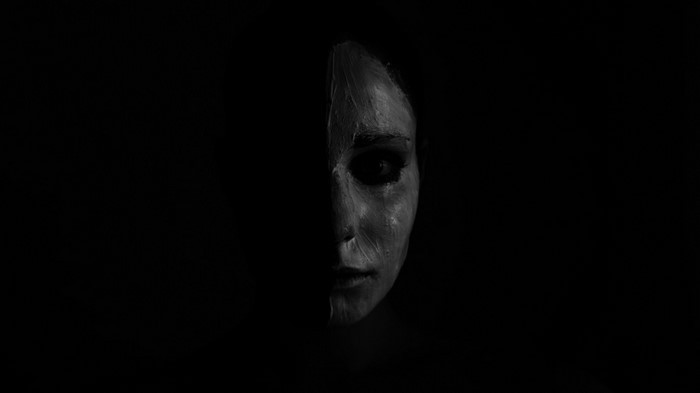 Monochrome portrait of a woman with half her face painted white