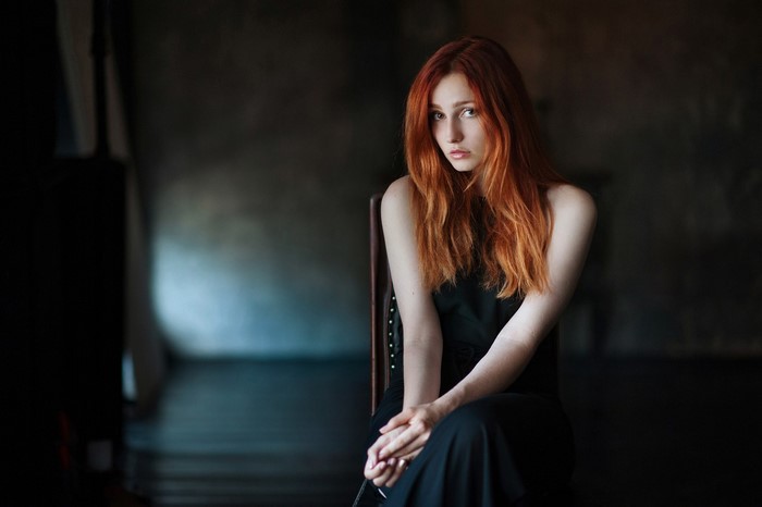 Redhead woman sitting in a black dress