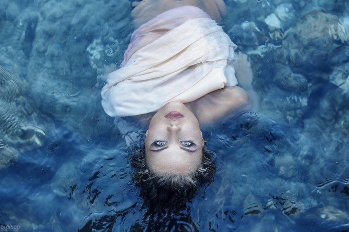 Woman with blue eyes floating in water