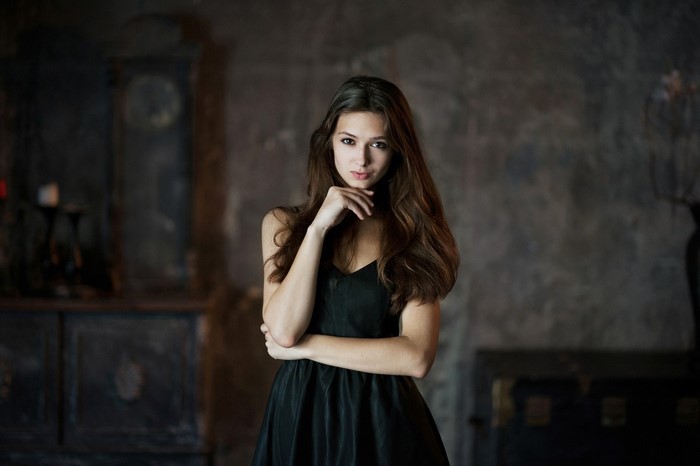Woman in black dress posing indoors