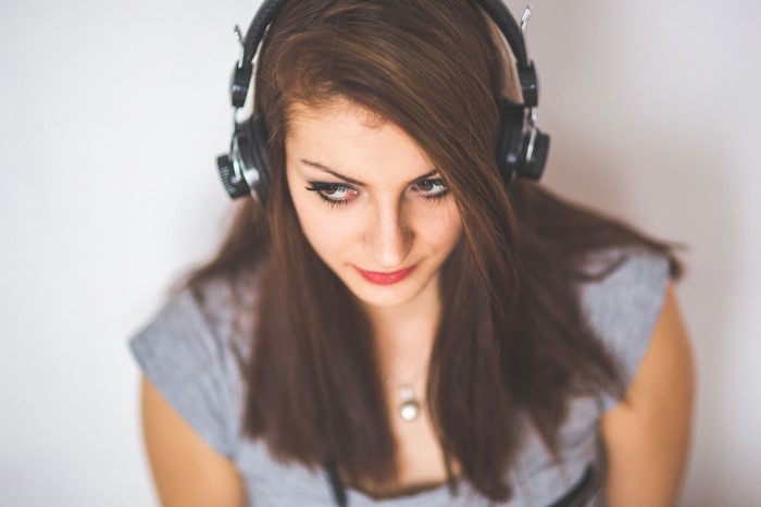 Woman wearing headphones looking down
