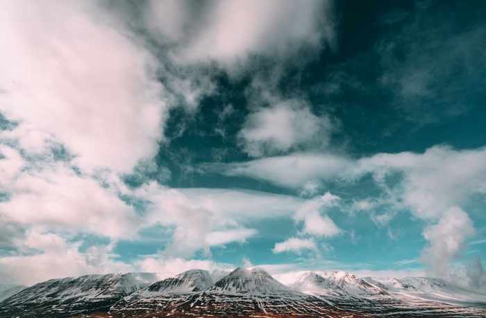 Snow-capped mountains under a cloudy sky