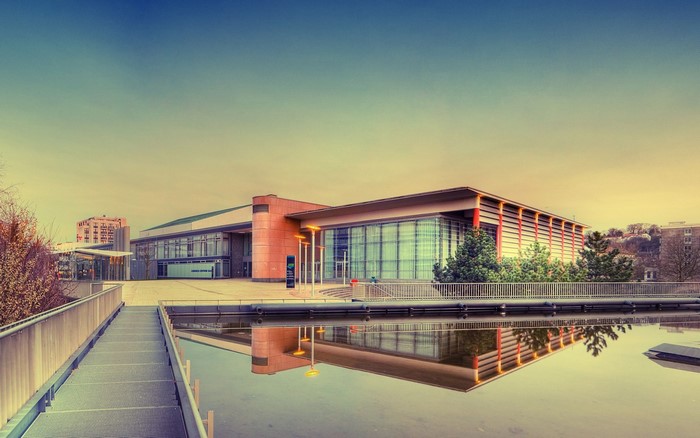 Modern building with reflection in water at sunset