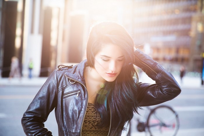Woman in leather jacket with hand in hair