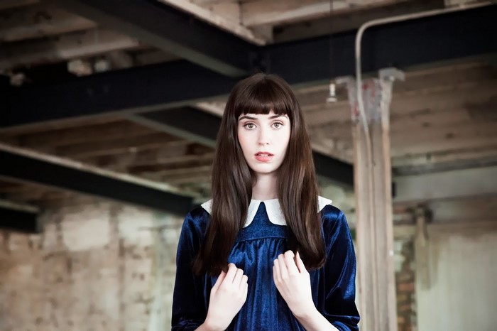 Woman in blue velvet dress with white collar