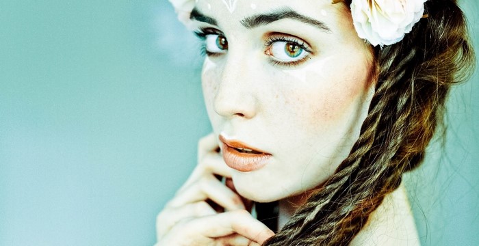 Portrait of a young woman with braids and face paint