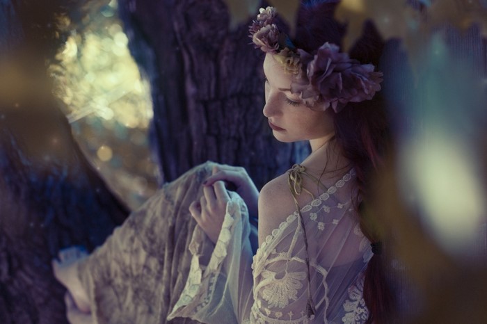Woman with flower crown in ethereal forest setting